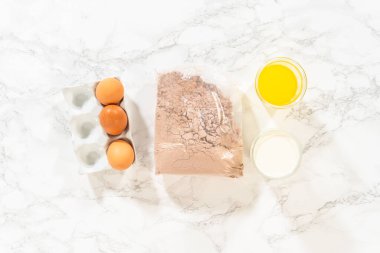 Düz yatıyordu. Ölçülü malzemeler tezgahın üzerinde toplandı. Birleştirilmeye ve bu lezzetli çikolatalı keki yapmaya hazır..