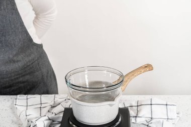 Çikolata parçacıkları ve diğer malzemeleri kaynayan suyun üzerine karıştırıp sade şekerleme hazırlamak..