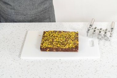 Scoring chocolate pistachio fudge into perfect squares for cutting.