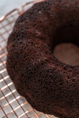 Chocolate Bundt Pastası dikkatlice tavadan çıkartılır. Yuvarlak soğutma rafına yerleştirilir. Kusursuz bir sunum ve hoş bir hoşgörü için hazırlanır..