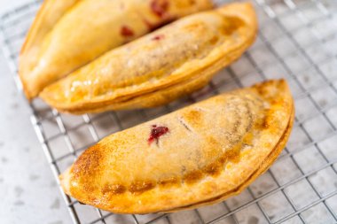 Mutfak tezgahındaki tavada taze pişmiş vişneli börek var..