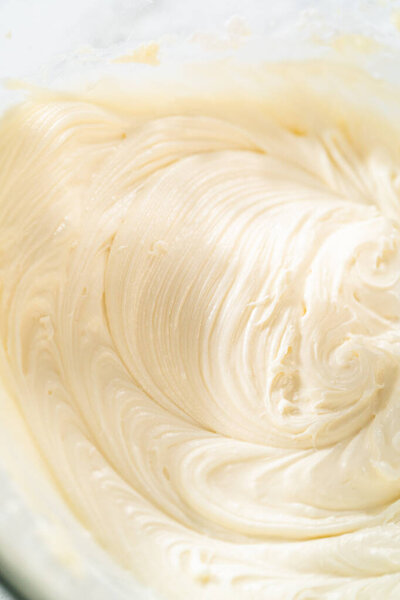 In a large mixing bowl, the ingredients are expertly mixed to create a delectable cream cheese buttercream for the Carrot Bundt Cake.