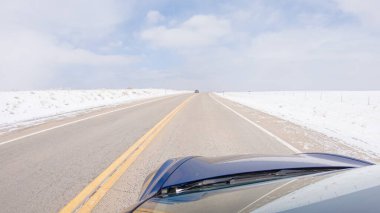 Kış sonrası fırtınada önden giden bir yol huzurlu bir sürüş sunuyor. Etrafı karla kaplı olan manzara, huzurlu ve resimsel çevreye katkıda bulunarak, sürüş gücünü artırıyor.