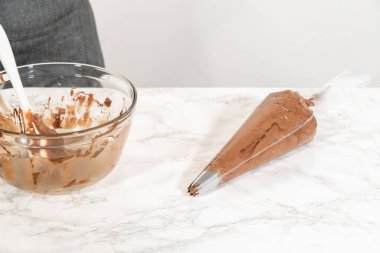 Çikolata kreması özenle bir torbaya aktarılıyor. Lezzetli kekleri süslemeye hazır..