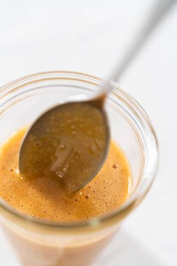 Karamelli kek için mutfak tezgahındaki cam kavanozda.