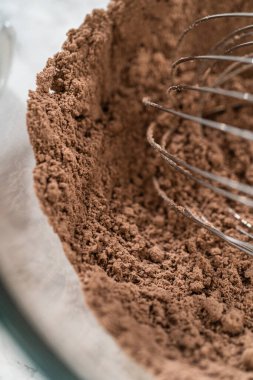 Ağız sulandıran çikolatalı kekler yapma sürecinde ilk adım, mükemmel hamur makinesini yapmak için malzemeleri titizlikle karıştırmayı içerir..