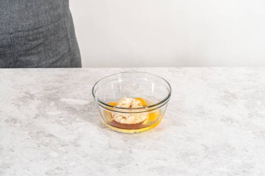 Küçük bir bardakta ıslak malzemeler karıştırmak havuçlu kek yapmak için krem peynirli pasta.