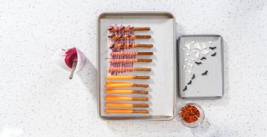 Düz yatıyordu. Çubuk krakerleri erimiş çikolataya batırıp Cadılar Bayramı 'nda çikolata kaplı çubuk kraker yapmak..