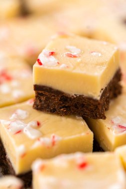 Büyük bir mutfak bıçağıyla şeker kamışı şekerlemesini beyaz bir kesme tahtasında kare parçalara ayırmak..