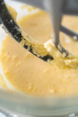 Mixing ingredients in kitchen electric mixer to bake American flag mini cupcakes.