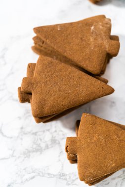 Süslenmemiş zencefilli kurabiye yığınları kraliyet kreması ile süslenmeye hazır..