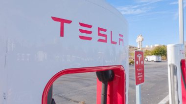 Primm, Nevada, ABD-3 Aralık 2022 - Gün içinde, Tesla süperşarj istasyonunda bir Tesla aracı şarj olurken görüldü, kullanışlı ve verimli olması için yüksek hızlı şarj altyapısını kullandı