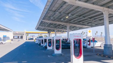 Baker, California, ABD-3 Aralık 2022-Gün boyunca Tesla bir süper şarj istasyonunda yüksek hızlı şarj altyapısını uygun ve verimli bir şekilde kullanan bir Tesla aracı görüldü.