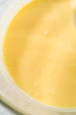 Limonlu yaban mersinli kek pişirmek için büyük bir bardakta ıslak malzemeler karıştırıyorum..