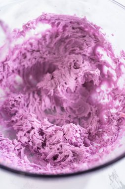 Eldeki görev, taze pişmiş vanilyalı ve çikolatalı keklerin üzerine ustalıkla borulamak üzere lezzetli bir krema kreması yapmak..