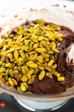 Melting white chocolate chips and other ingredients in the double boiler to prepare chocolate pistachio fudge.