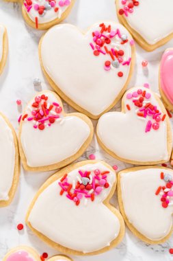 Sevgililer Günü için pembe ve beyaz kraliyet kremalı kalp şeklinde kurabiyeler..