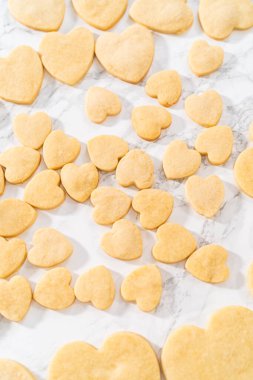 Sevgililer Günü için pembe ve beyaz kraliyet kremalı kalp şeklinde kurabiyeler..