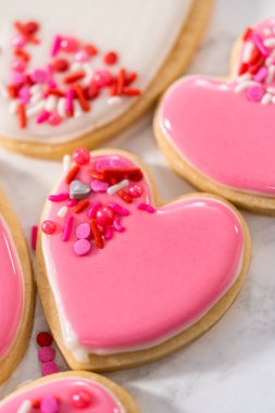 Sevgililer Günü için pembe ve beyaz kraliyet kremalı kalp şeklinde kurabiyeler..