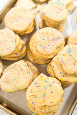 Büyük miktarda şekerli kurabiye düzgünce pişirme tepsisine istiflenmiş, paketlerinin kırsal kahverengi karton kutulara konmasını bekliyor..