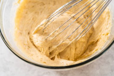 Islak ve kuru malzemelerle bardakta çırpma kabını karıştırıp krem peynirli havuçlu kek pişirmek..