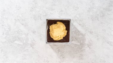 Düz yatıyordu. Çubuk şekerleme hazırlamak için kareli peynirli kek kalıbını parşömen kağıdıyla dolduruyorum..