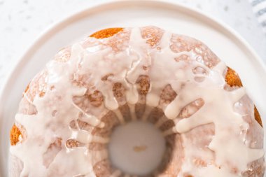 Taze pişmiş basit vanilyalı kek servis tabağında beyaz jöleli.