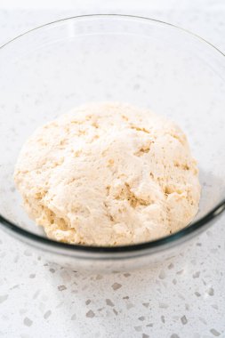 Cam bir kasede yükselen hamurlar naan dippers pişirmek için karıştırılıyor..