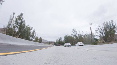 Yağmurlu bir kış gününün ortasında, Los Angeles, Kaliforniya yakınlarındaki HWY 134 'te, yağmur damlalarıyla kaplı lenslerle atmosferi yakalıyor, ve bu yolculuğa benzersiz ve dengesiz bir perspektif ekliyor..