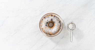 Düz yatıyordu. Taze fırınlanmış limonlu yaban mersinli kekin tozunu alıyorum..