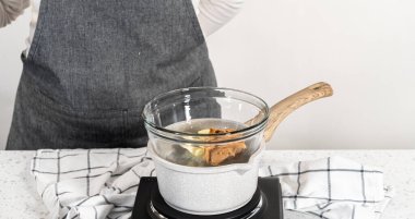 Çikolata parçacıkları ve diğer malzemeleri kaynayan suyun üzerine karıştırıp sade şekerleme hazırlamak..