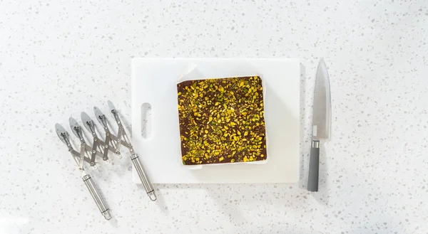 Flat Lay Removing Chocolate Pistachio Fudge Square Cheesecake Pan Lined — Stockfoto