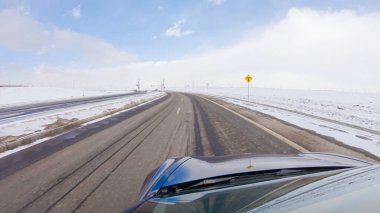 Kış sonrası fırtınada önden giden bir yol huzurlu bir sürüş sunuyor. Etrafı karla kaplı olan manzara, huzurlu ve resimsel çevreye katkıda bulunarak, sürüş gücünü artırıyor.