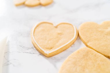 Sevgililer Günü için pembe ve beyaz kraliyet kremalı kalp şeklinde kurabiyeler..