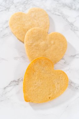 Sevgililer Günü için pembe ve beyaz kraliyet kremalı kalp şeklinde kurabiyeler..