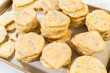 Büyük miktarda şekerli kurabiye düzgünce pişirme tepsisine istiflenmiş, paketlerinin kırsal kahverengi karton kutulara konmasını bekliyor..