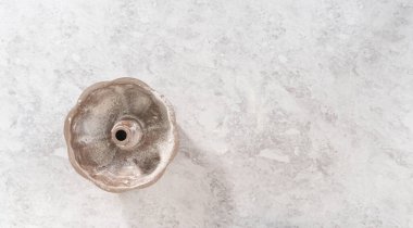 Flat lay. Greasing metal bundt cake pan to bake carrot bundt cake with cream cheese frosting.