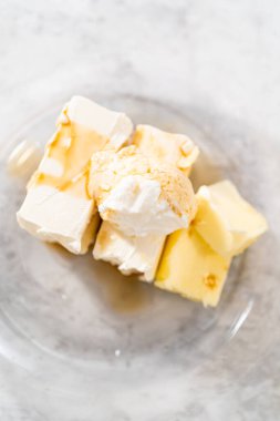 Krem peynirli krema yapmak için cam karıştırma kabında ölçülmüş malzemeler..