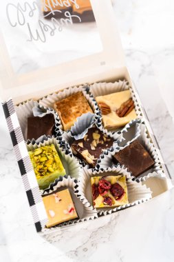 Noel hediyeleri için ev yapımı şekerleme paketlerini teneke kutulara koyuyoruz..