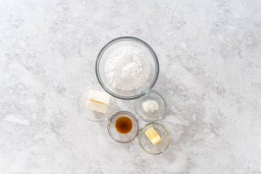 Düz yatıyordu. Krem peynirli krema yapmak için cam karıştırma kabında ölçülmüş malzemeler..