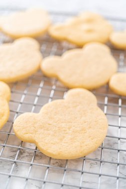 Cooling panda-shaped shortbread cookies on a cooling rack at the kitchen counter.