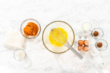 Düz yatıyordu. Sıcak bir mutfakta, büyük bir karıştırma kabı malzemelerin ustalıkla harmanlanması için sahne olur, kek karışımından nefis bir ev yapımı balkabağı pastası hazırlamak için sahne hazırlar.