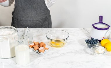 Cam bir kasenin içindeki bileşenleri birleştirmek, bir çırpıcıyla karıştırmak, limonlu-yabanmersinli kek hazırlamak..