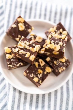 Beyaz tabakta ev yapımı çikolatalı fındıklı şekerleme parçaları..