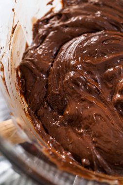 Çikolata parçacıkları ve diğer malzemeleri kaynayan suyun üzerinde karıştırarak fındıklı çikolatalı şekerleme hazırlıyorum..