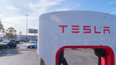 Primm, Nevada, ABD-3 Aralık 2022 - Gün içinde, Tesla süperşarj istasyonunda bir Tesla aracı şarj olurken görüldü, kullanışlı ve verimli olması için yüksek hızlı şarj altyapısını kullandı