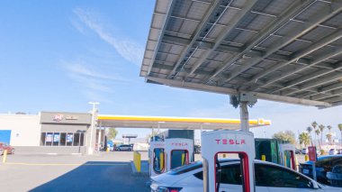 Baker, California, ABD-3 Aralık 2022-Gün boyunca Tesla bir süper şarj istasyonunda yüksek hızlı şarj altyapısını uygun ve verimli bir şekilde kullanan bir Tesla aracı görüldü.