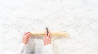 Düz yatıyordu. Tarçın ile doldurulmuş rulo ekmek hamuru ve daha küçük rulolara doğranmış fındıklar tarçınsız kek pişirmek için..