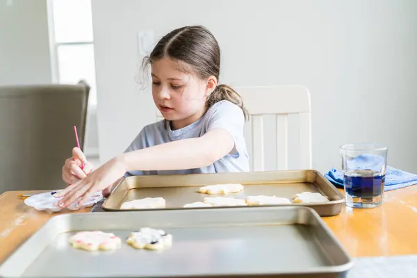 一个小女孩细心地写下了一个感人的场景 在糖饼干上涂上了食物的颜色 饼干上撒满了白色的皇家糖霜 真叫人难过 — 图库照片