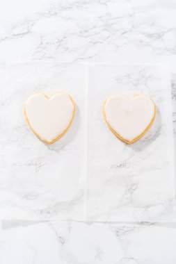 Sevgililer Günü için pembe ve beyaz kraliyet kremalı kalp şeklinde kurabiyeler..